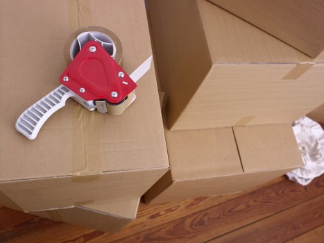 Professional movers handling furniture in a Kensington flat with narrow access
